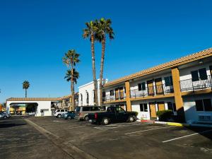 um parque de estacionamento em frente a um hotel com palmeiras em Casa Blanca Express & Suites Cypress Buena Park - Anaheim Area em Cypress
