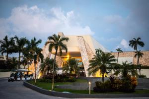 a building with palm trees in front of it at Grand Sirenis Riviera Maya Resort & Spa All Inclusive in Akumal