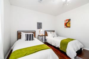 Duas camas num quarto com paredes brancas em The Eagles Nest em Bentonville