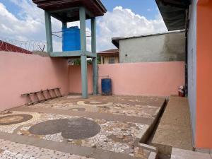 un patio vacío con una torre azul en la parte superior de un edificio en Charmante maison cozy et conviviale en Bafoussam