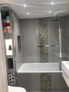 a bathroom with a shower with a tub and a sink at One bedroom apartment in Goodmayes