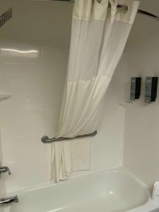 łazienka z białą wanną i zasłoną prysznicową w obiekcie Best Western Pawleys Island w mieście Pawleys Island