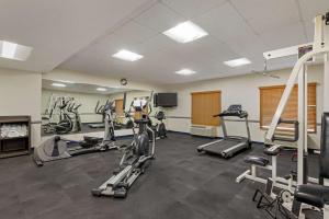 a gym with several treadmills and machines in a room at Best Western PLUS Executive Hotel Richmond in Richmond