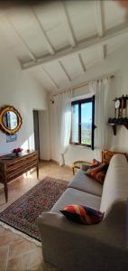 uma sala de estar com um sofá e uma grande janela em Aurinia em Saturnia