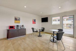 Habitación con 2 mesas, sillas y TV. en Motel 6-Clovis, NM, en Clovis