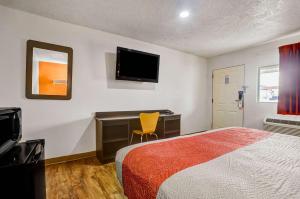 um quarto de hotel com uma cama, uma secretária e uma televisão em Motel 6-Clovis, NM em Clovis