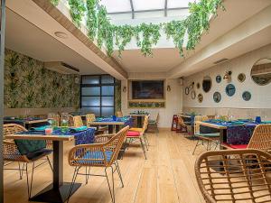 ein Restaurant mit Tischen und Stühlen und einem Dachfenster in der Unterkunft Hostal Real Aranjuez in Aranjuez