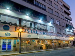 un edificio con un letrero para un restaurante en una calle en Hostal Real Aranjuez, en Aranjuez