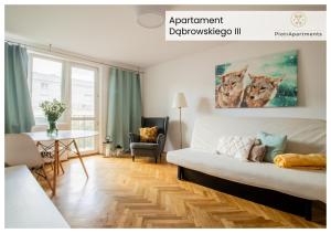 ein Wohnzimmer mit einem weißen Sofa und einem Tisch in der Unterkunft PiotrApartments IV in Warschau