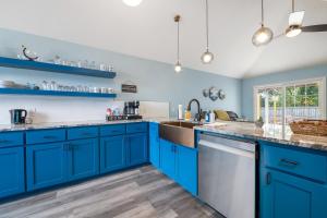 eine blaue Küche mit blauen Schränken und einem Waschbecken in der Unterkunft The Nessie in Bentonville