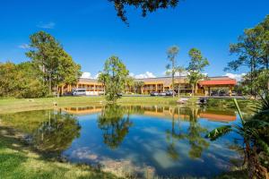 a large building with a pond in front of it at SureStay Hotel by Best Western St Pete Clearwater Airport in Clearwater