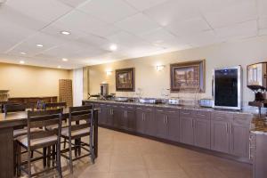 a restaurant with a long bar with wooden tables and chairs at SureStay Hotel by Best Western St Pete Clearwater Airport in Clearwater