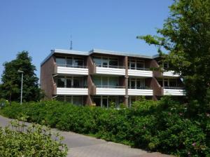 a large brick building with bushes in front of it at Ferienwohnung Hansens in Dangast