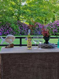 a bottle of wine sitting on a table with wine glasses at Ferienwohnung Hansens in Dangast