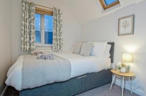 ein Schlafzimmer mit einem großen Bett und einem Fenster in der Unterkunft StayRight 2 Bed Beach House with Private Parking- Next to Barry Beach and Jackson Bay in Barry