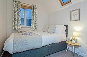 a bedroom with a large bed and a window at StayRight 2 Bed Beach House with Private Parking- Next to Barry Beach and Jackson Bay in Barry