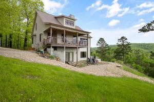 una casa al lado de una colina con césped en Lake Haven, en Eureka Springs