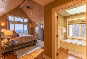een slaapkamer met een bed, een bad en een raam bij Skytop Retreat in Sugar Mountain