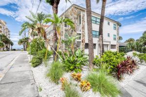 een straat voor een gebouw met palmbomen en planten bij Paralia Condo in Clearwater Beach