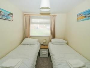 2 Betten in einem Zimmer mit Fenster in der Unterkunft The Bolthole in Dartmouth