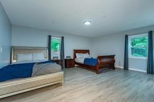 1 Schlafzimmer mit 2 Betten und 2 Fenstern in der Unterkunft Poconos Home with Marshall's Creek Views - Nearby Ski, HUGE Private 6 Bedroom Home! in East Stroudsburg