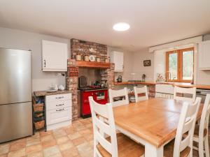 eine Küche mit einem Holztisch und einem Kühlschrank in der Unterkunft Coffeys in Ballymacarbry