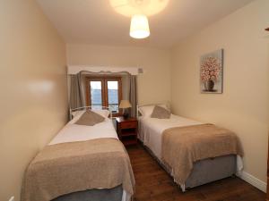 a bedroom with two beds and a window at Coffeys in Ballymacarbry
