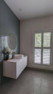 een badkamer met een wastafel, een spiegel en een raam bij Location & luxury 2BR 2 Bath in Albury
