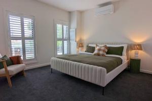 - une chambre avec un grand lit et 2 fenêtres dans l'établissement Location & luxury 2BR 2 Bath, à Albury