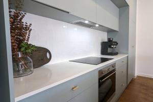 a kitchen with white counters and a stove top oven at Location & luxury 2BR 2 Bath in Albury