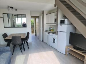 a living room with a dining room table and a kitchen at Appartement Arzon, 2 pièces, 5 personnes - FR-1-639-17 in Arzon