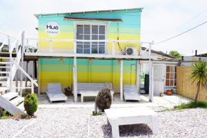 a cat sitting on a patio in front of a house at Hué Hostel in Punta Del Diablo