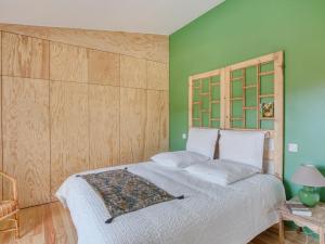 a bedroom with a white bed with a wooden headboard at Maison 3 étoiles, piscine chauffée, accès plage privée, 12 couchages, proche lac et forêt - FR-1-521-185 in Biscarrosse