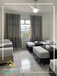a bedroom with two beds and a window at Angra Hostel 147 in Angra dos Reis