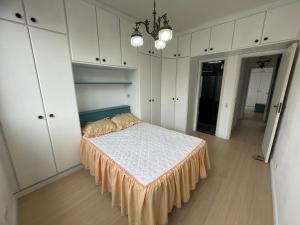 a bedroom with a bed and white cabinets at Praia Gonzaga, Santos in Santos