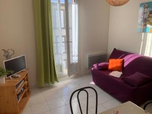 a living room with a purple couch and a tv at Appartement Mont-Dore, 2 pièces, 4 personnes - FR-1-415-129 in Le Mont-Dore