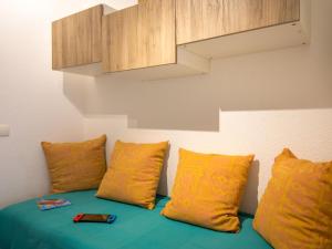 um sofá com almofadas amarelas e uma prateleira de madeira em Studio Saint-Raphaël, 1 pièce, 3 personnes - FR-1-466A-43 em Saint-Raphaël