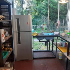 cocina con nevera, mesa y ventana en CASA CONTAINER BOSQUE Y MAR en Mar del Plata