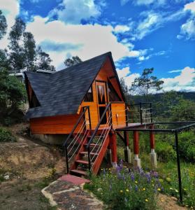una casa pequeña con techo negro en Glamping refugio Gaia, en Paipa