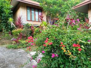 a garden with flowers in front of a house at The mantra resort in Ban Tha Rua