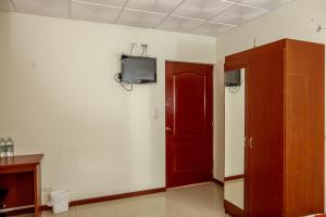 a room with a red door and a tv on a wall at Hotel Windsor Plaza in San Salvador