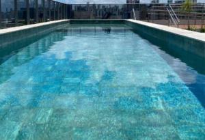 una gran piscina de agua azul en un edificio en Box 150 Joia Rara no Caribessa, en João Pessoa