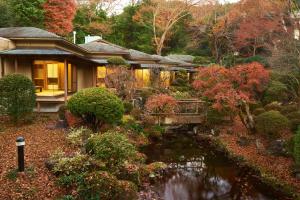 una casa con un estanque frente a un jardín en 熱海慧薗貸し切り en Atami