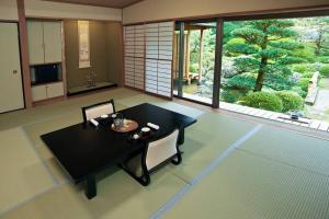 sala de estar con mesa y ventana grande en 熱海慧薗貸し切り, en Atami