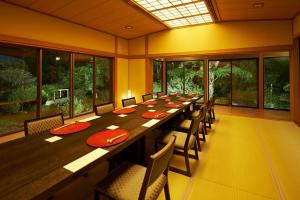 una grande sala da pranzo con un lungo tavolo e sedie di 熱海慧薗貸し切り ad Atami
