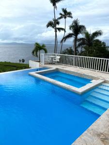 a large blue swimming pool next to the ocean at Beautiful View!! in Santa Bárbara de Samaná