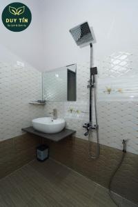 a bathroom with a sink and a mirror and a shower at Xuân Hải Complex-Hotel in Song Cau +7 photos