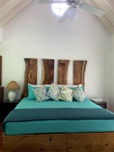 um quarto com uma cama com lençóis e almofadas azuis em Reefside Villa em Crown Point