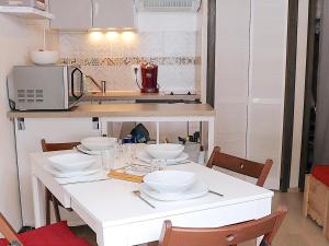 - une cuisine avec une table blanche et de la vaisselle dans l'établissement Studio cosy entre pistes et sentiers – Parking inclus - FR-1-498-71, à Bernex