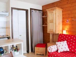 un salon avec un canapé rouge et une cuisine dans l'établissement Studio cosy entre pistes et sentiers – Parking inclus - FR-1-498-71, à Bernex